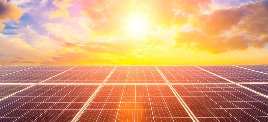 PLACAS DE ENERGIA SOLAR E AO FUNDO O SOL EM MEIO A NUVENS