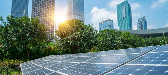 PLACAS DE ENERGIA SOLAR INSTALADAS EM UMA ÁREA EXTERNA A UMA GRANDE REGIÃO DE PRÉDIOS EMPRESARIAIS