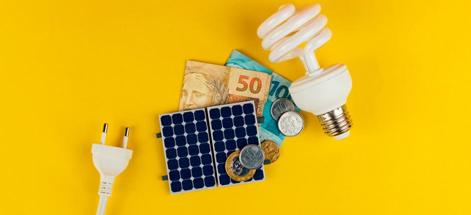 TOMADA DE ENERGIA, PLACA DE ENERGIA SOLAR FOTOVOLTAICA, MOEDAS, LÂMPADAS E AO FUNDO UMA COR AMARELA