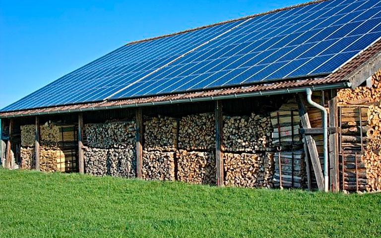 PLACAS DE ENERGIA SOLAR FOTOVOLTAICA INSTALADAS SOB UM GRANDE GALPÃO LOCALIZADO EM UMA FAZENDA
