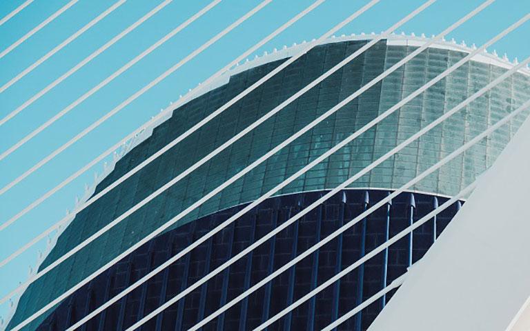 EDIFÍCIO COM LINHAS BRANCAS DIAGONAIS COM JANELAS DE VIDROS REFLETIVAS